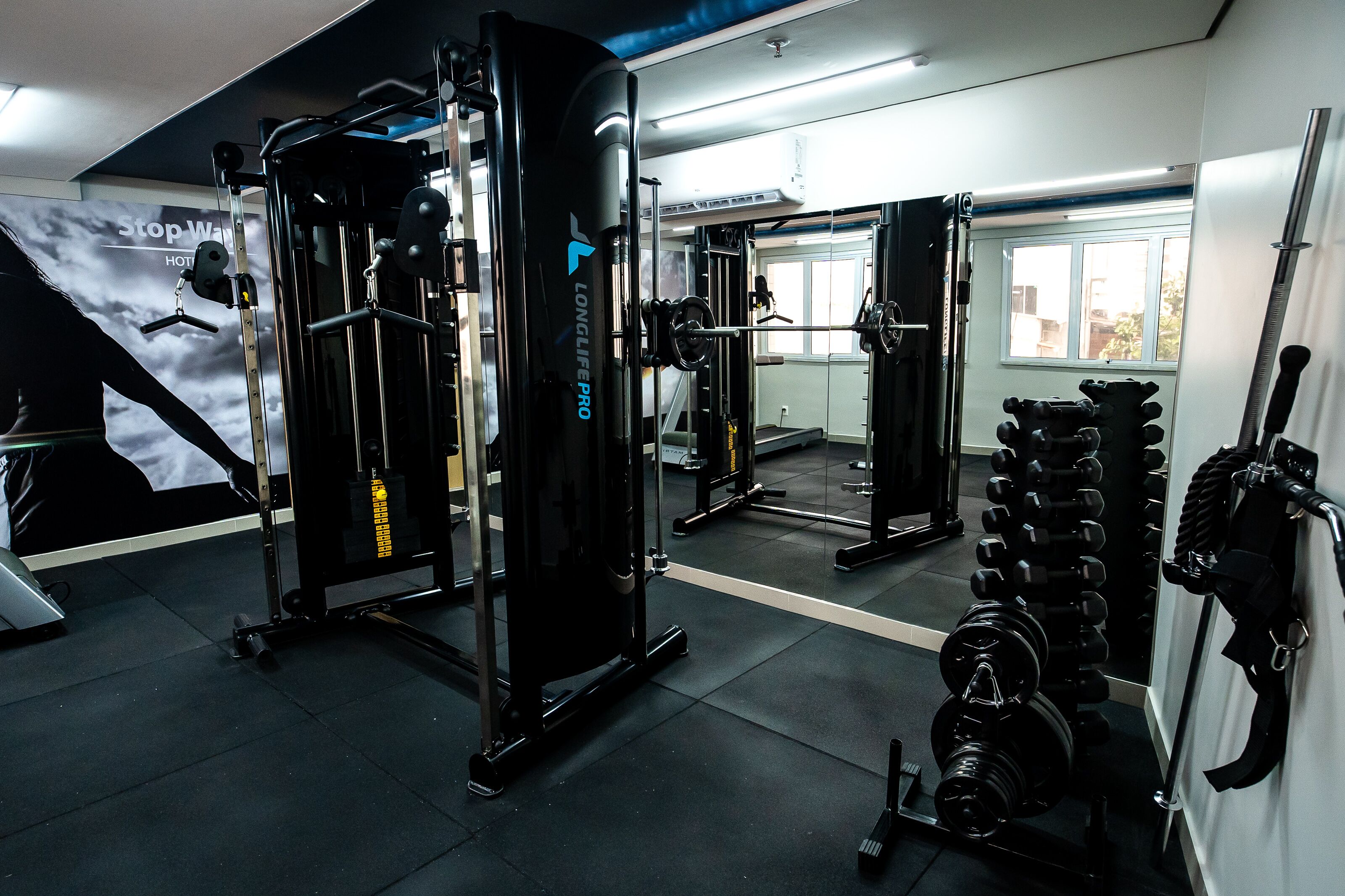 A gym with various exercise equipment, including a squat rack and weight benches.