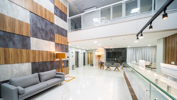 A modern interior with a grey sofa, a glass railing, and a checkered wall pattern. - Stop Way Hotel Fortaleza (Fortaleza)