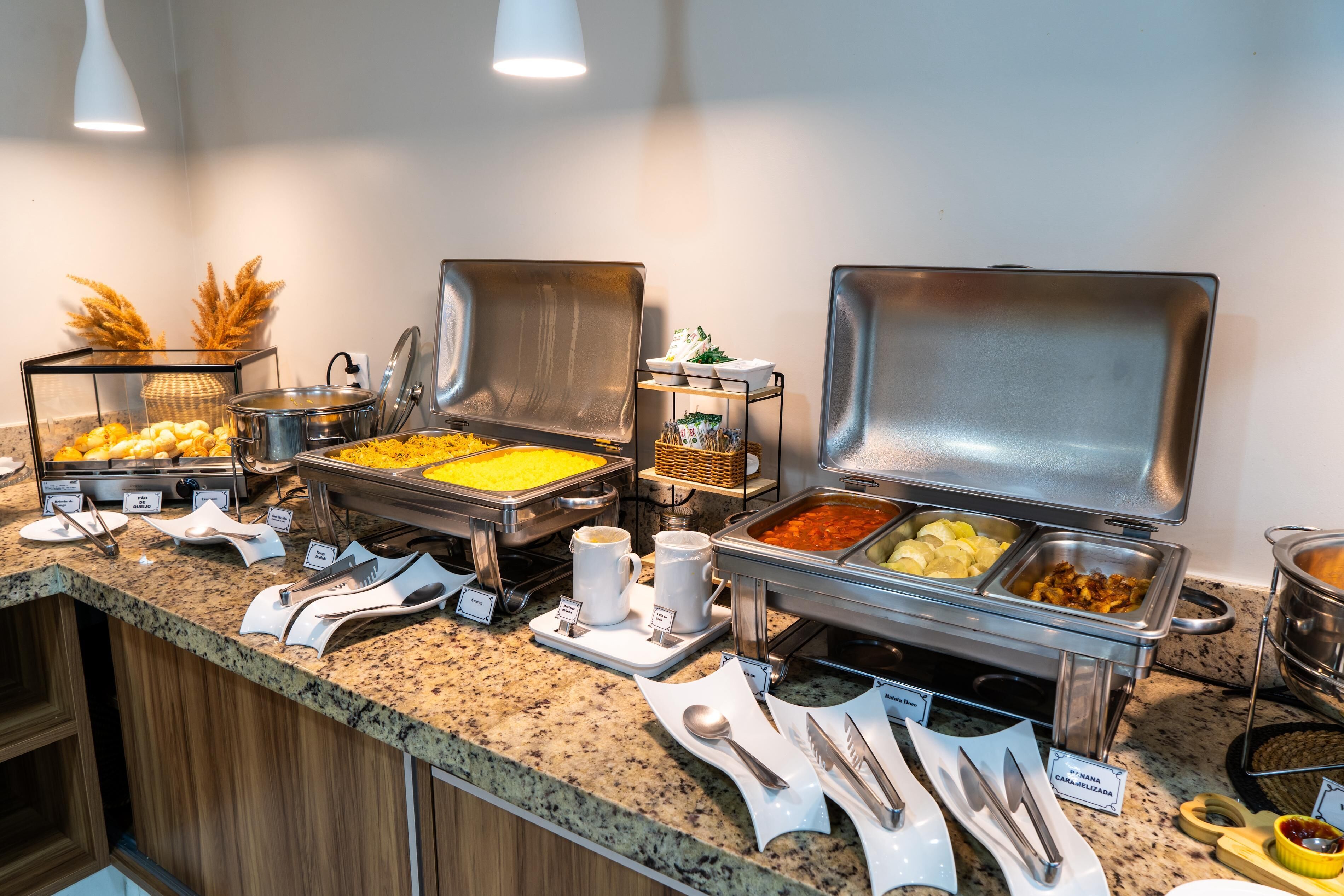 A buffet setup with various food items and utensils.