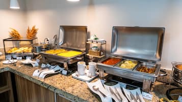 Una mesa de buffet con diferentes tipos de comida y utensilios.