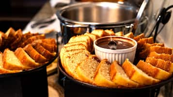 A buffet with sliced bread and a small bowl of sauce.