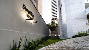 A hotel entrance with a modern design, a sign for 'Stop Way Hotel', and a paved pathway leading to the entrance. - Stop Way Hotel Fortaleza (Fortaleza)
