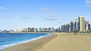 A beach with a city skyline in the background. - Stop Way Hotel Fortaleza (Fortaleza)