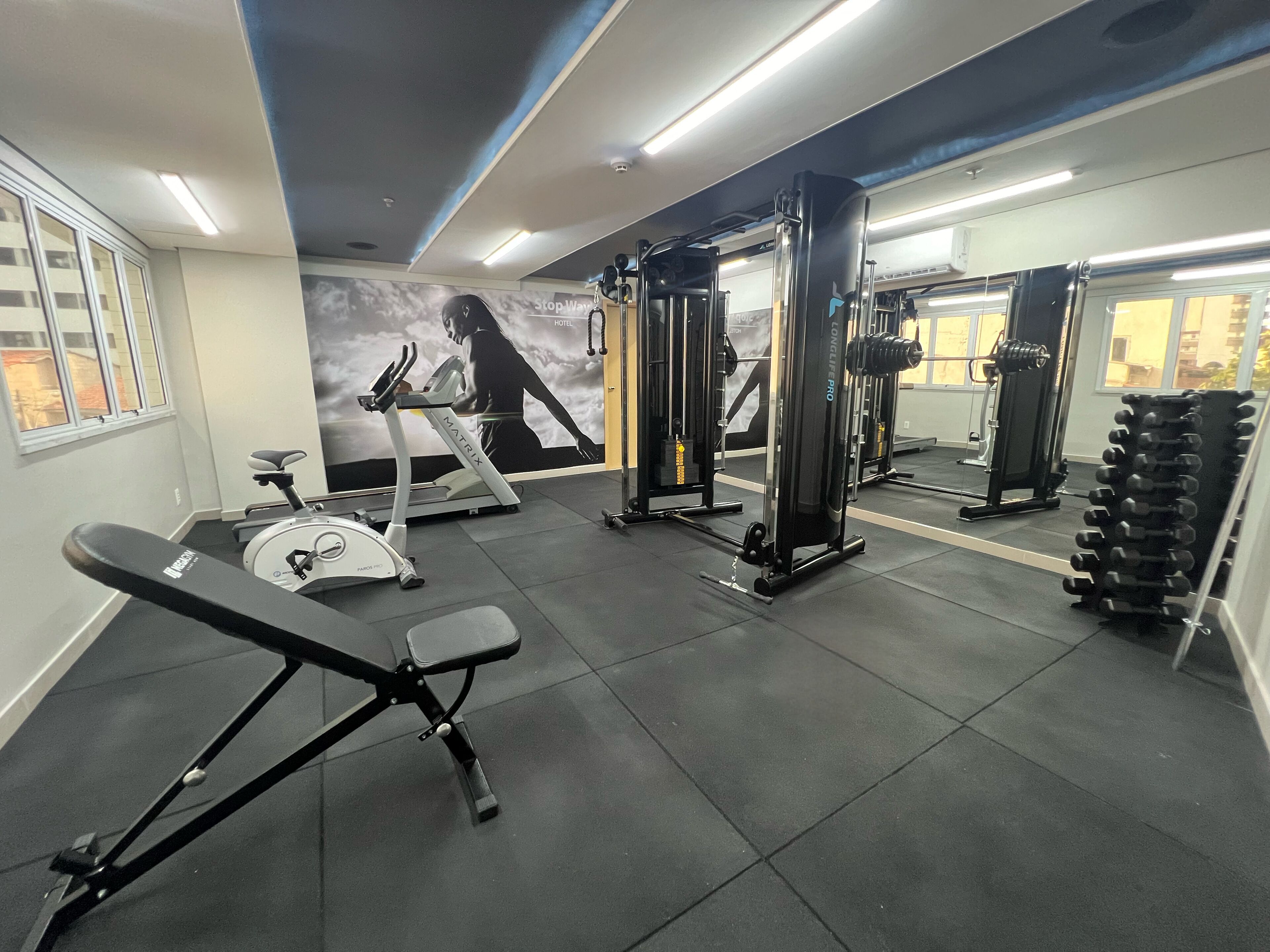 A gym with exercise equipment, a treadmill, and a mirror.