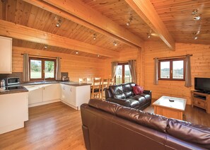 Eine geräumige Hütte mit Küche, Essbereich und Wohnzimmer.