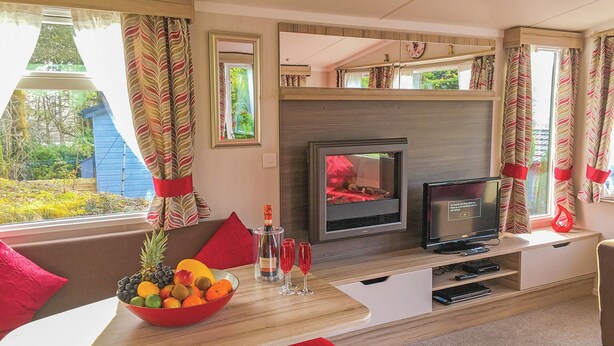A compact living space with a TV, seating area, and a fireplace.