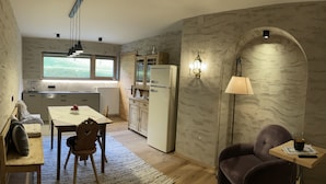 Una cucina compatta con angolo ristoro, un divano e un tavolino con lampada.