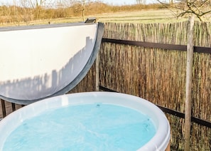 Une piscine avec une clôture en bois en arrière-plan.