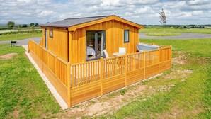 Une cabane en bois avec un balcon, une porte et une fenêtre.