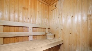 Un sauna en bois avec des bancs et un petit seau.