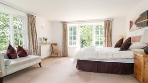 A bedroom with a bed, a chair, a sofa, and a dresser.