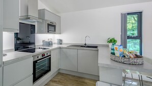 Een moderne keuken met een ingebouwde oven, magnetron en gasfornuis.