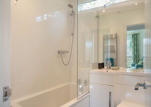 A modern bathroom with a glass shower enclosure, a bathtub, and a vanity with a mirror. - Comfortable log cabin offering self-catering in the heart of Cornwall. (Ruthernbridge, Nr Bodmin)