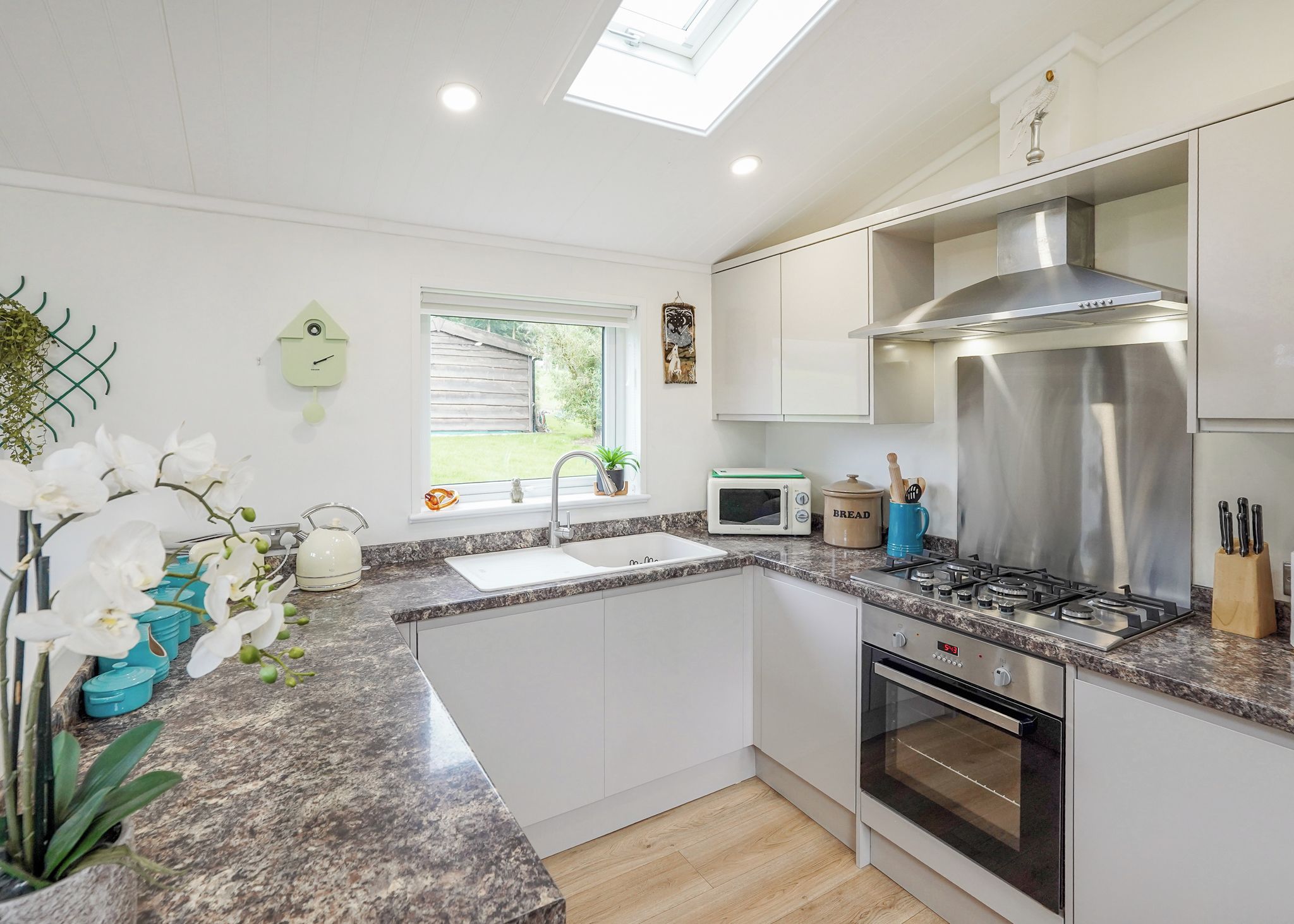 A modern kitchen with a built-in oven, microwave, and stainless steel range hood.