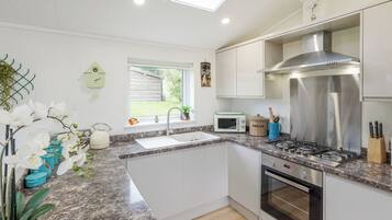 A modern kitchen with a built-in oven, microwave, and stainless steel range hood.