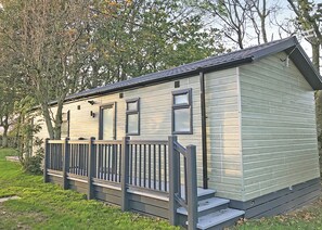 A single-story mobile home with a front porch, a small window, and a door.