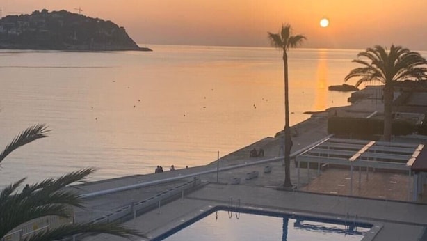 A pool area with a view of the sea and a sunset. - Santa Ponsa Mallorca first line of sea - Aparthotel (Santa Ponça)