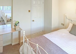 A bedroom with a bed, bedside table, and a mirror. - 3 bedroom accommodation in Easingwold (Easingwold)