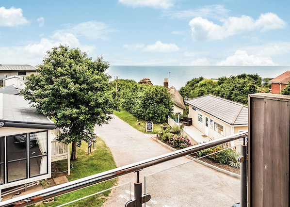 Ein Wohngebiet mit Blick auf das Meer, einem Weg und einem Haus mit sichtbarer Haustür und Fenstern.