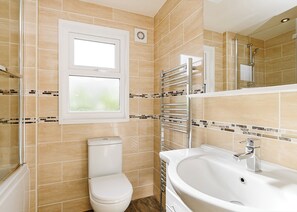 Un baño con inodoro, lavabo y ventana.