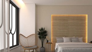 Ein modernes Schlafzimmer mit Bett, Stuhl, Nachttisch und Wand mit strukturierter Oberfläche.