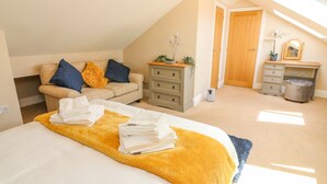 Une chambre à coucher avec un lit, une commode, un bureau et une fenêtre.