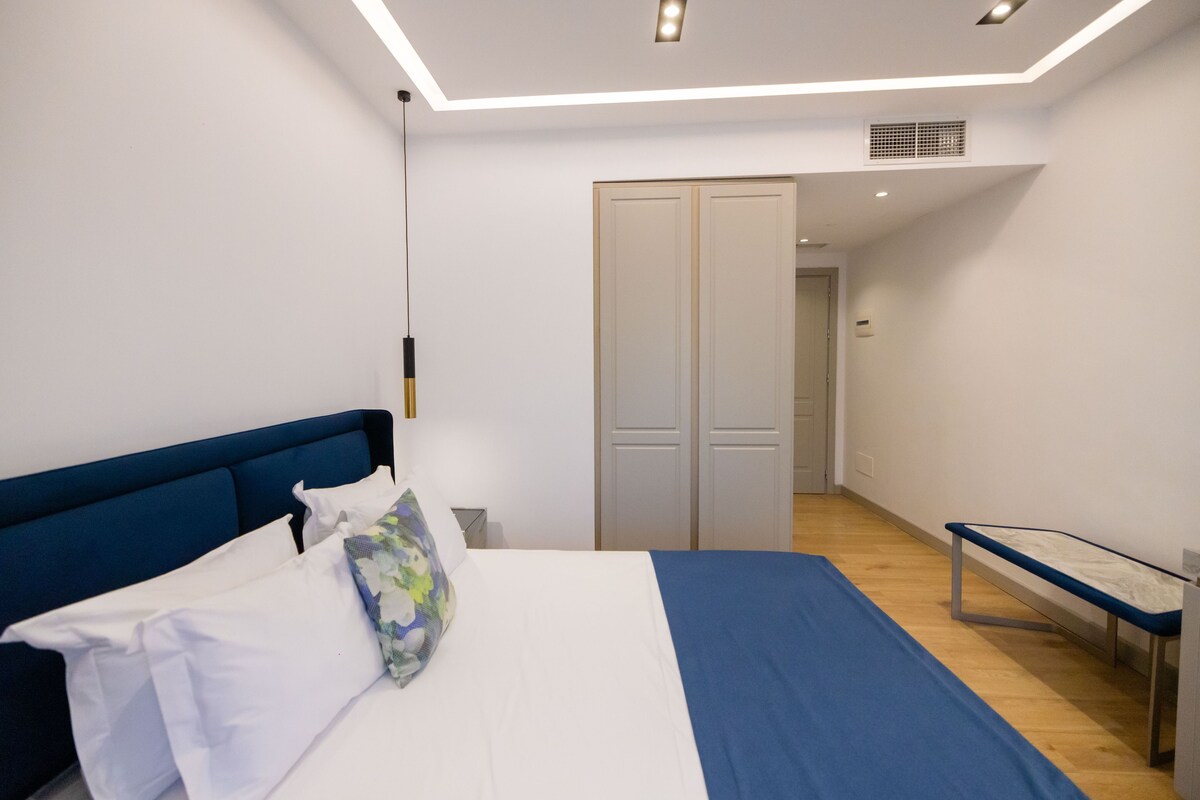 A bedroom with a bed, bedside table, and a wardrobe.