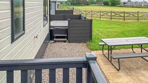 A patio area with a wooden deck, a bench, and a picnic table. - Spacious and comfortable holiday home featuring your own private hot tub. (Laurenkirk)