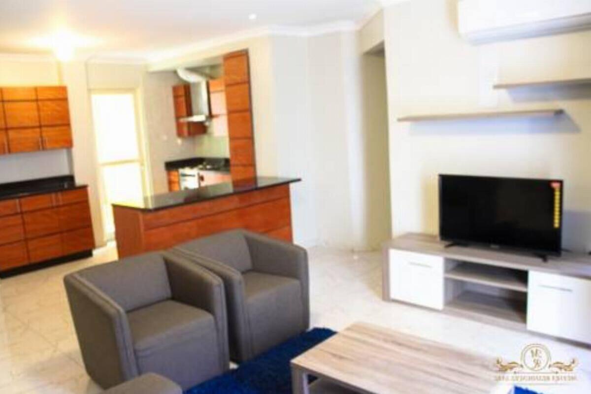 A modern living room with a flat-screen TV, grey sofas, and a wooden coffee table.