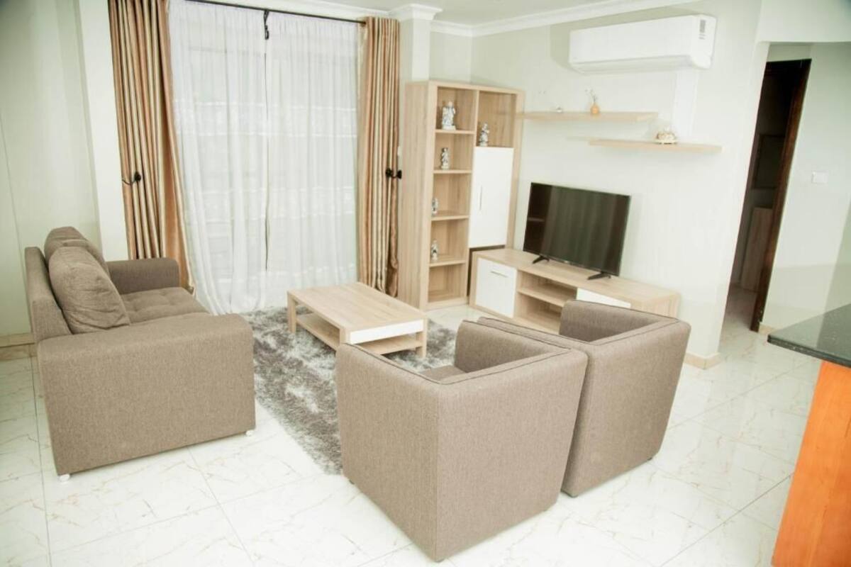 A living room with a sofa, a coffee table, a TV stand, and a bookshelf.