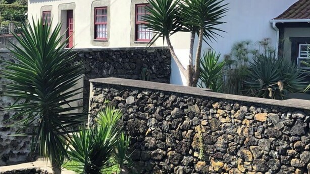 A white building with three windows and a stone wall in front. - Modernly Equipped Country House, 5 minutes from Natural Swimming Pools (Altares)