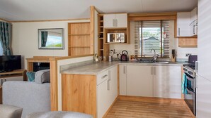A compact kitchen with wooden cabinets, a built-in microwave, and a stove.
