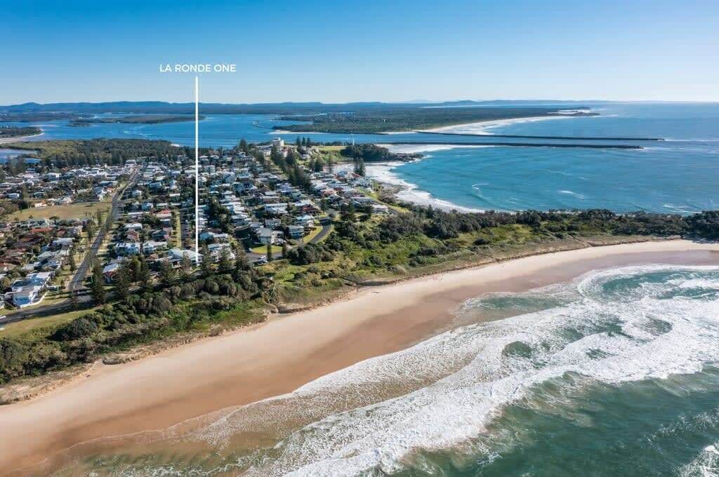 A coastal town with a beach, houses, and a lighthouse labeled "LA RONDE ONE".
