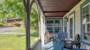 Une véranda avec des chaises bleues et une balustrade en bois.