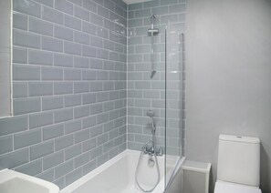 Une salle de bain avec une baignoire, une douche et des toilettes.