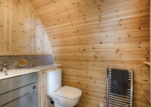 A wooden-paneled bathroom with a toilet, sink, and towel rack. - 0 bedroom accommodation in Great Busby (Great Busby)