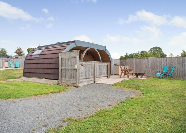A wooden shed with a sloped roof, a door, and a window.