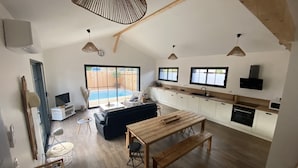 A spacious kitchen with white cabinets, a wooden countertop, and a built-in oven. - Wooden villa with pool (Arès)