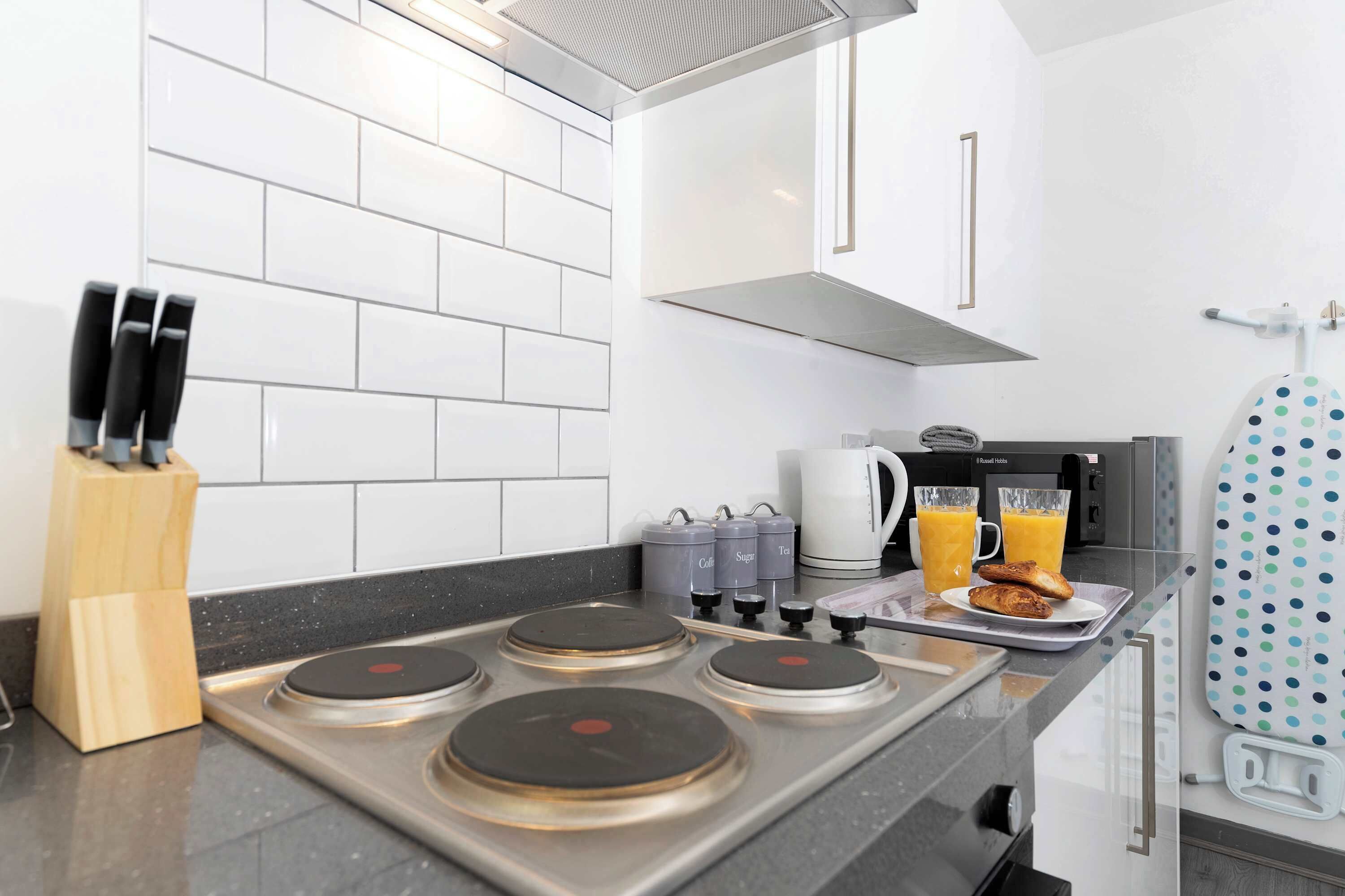 Une cuisine moderne équipée d’une cuisinière à gaz, d’une machine à café et d’une bouilloire.