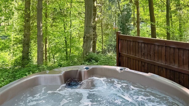 A hot tub in a forested area with a wooden deck. - 3 bedroom accommodation in Ellesmere (Ellesmere)