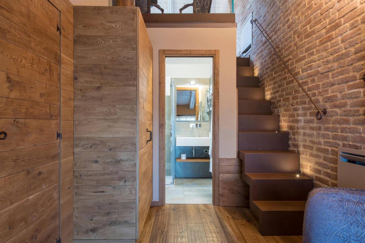 Un escalier en bois menant à une salle de bain au design moderne.