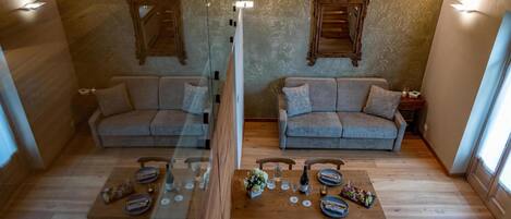 A mirrored room with two sofas, a wooden table set for dining, and wall-mounted mirrors.