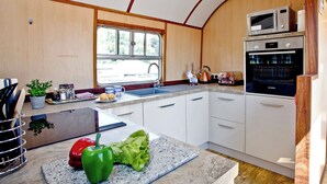 Una cocina moderna con un lavamanos, encimera y electrodomésticos, incluyendo un microondas y un horno.