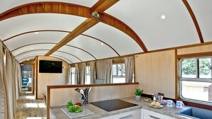 Una cocina con techo de madera, un lavamanos y un ventanal.