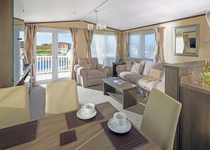 Un intérieur moderne comprenant un coin repas, un canapé et un balcon avec vue.