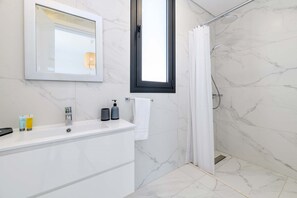 Regadera, secadora de cabello, shampoo, papel de baño 