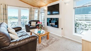 A modern living room with a leather sofa, a wooden coffee table, and a fireplace.
