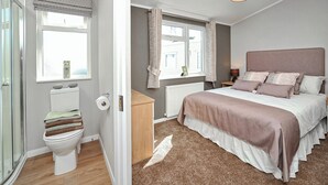 Une chambre à coucher avec un lit, une fenêtre, un radiateur et des toilettes.