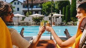 Una piscina cubierta, una piscina al aire libre de temporada, sombrillas