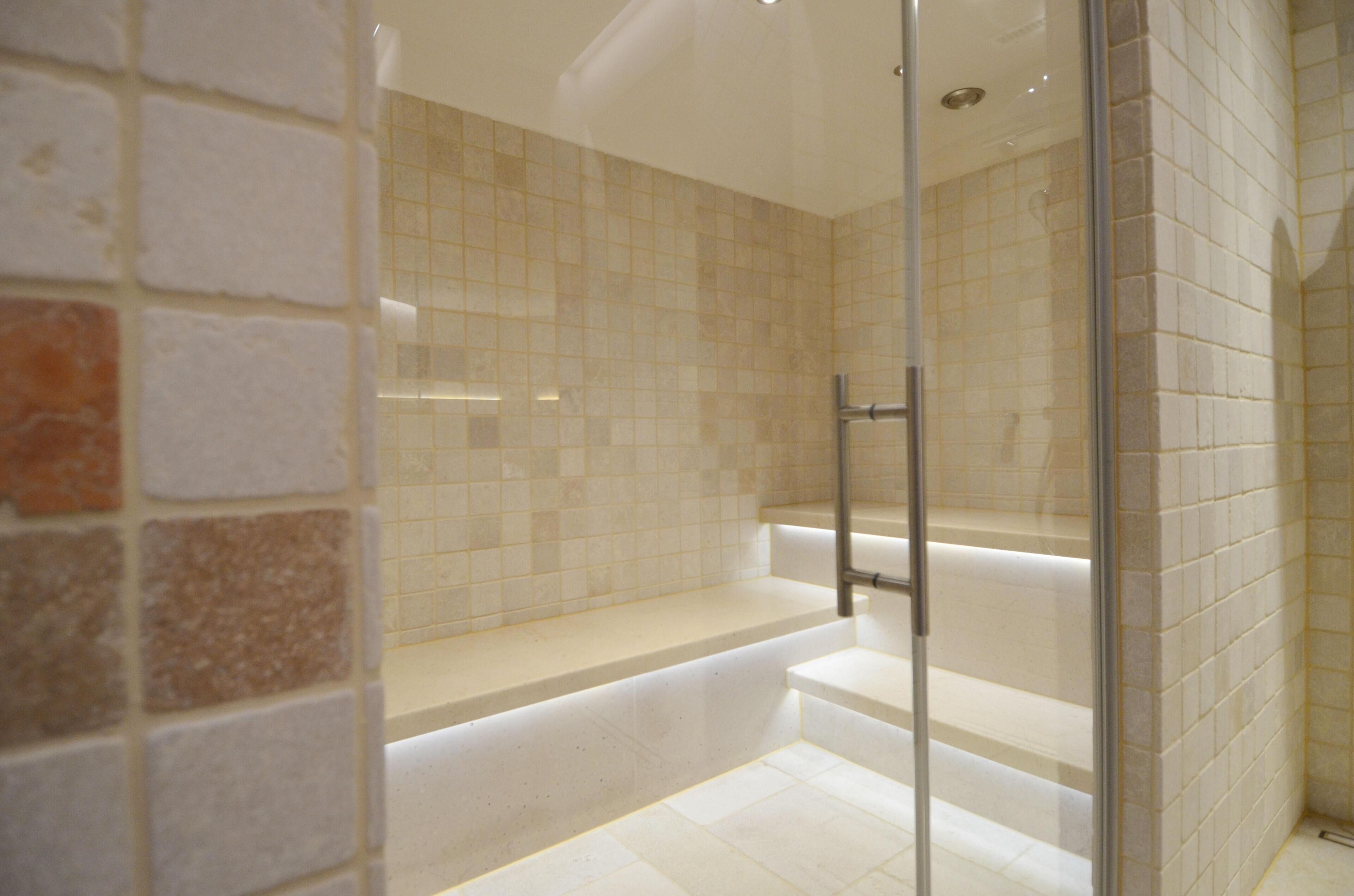 Ein modernes Badezimmer mit Duschkabine aus Glas, einer Badewanne und einem gefliesten Boden.